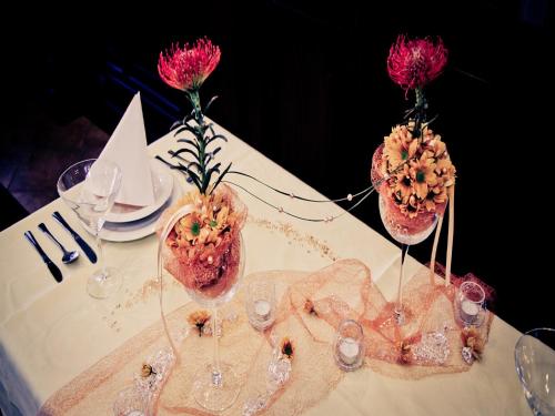a table with three vases with pink flowers on it at La Fresca in Kroměříž