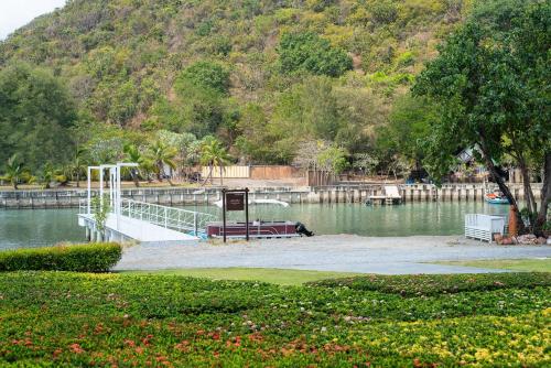 a dock in the middle of a body of water at La Isla Pranburi Beach Resort in Sam Roi Yot