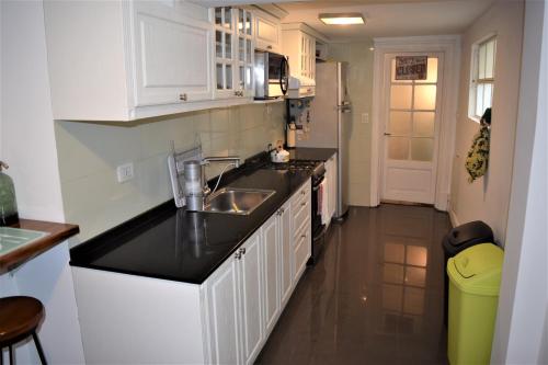 a kitchen with white cabinets and a sink at La Casa de Lola BA in Buenos Aires