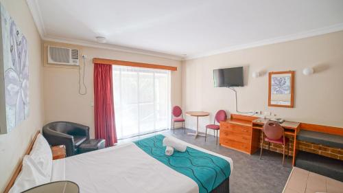 a hotel room with a bed and a desk at Country 2 Coast Motor Inn Coffs Harbour in Coffs Harbour