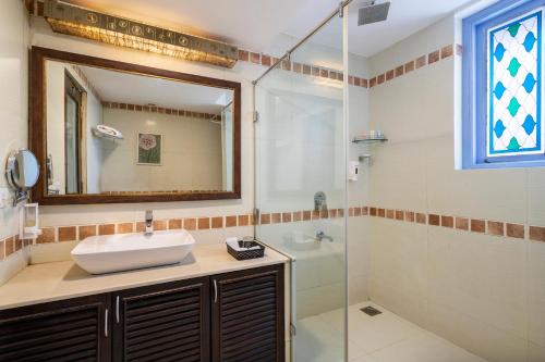a bathroom with a sink and a mirror and a shower at Varanda Do Mar in Panaji