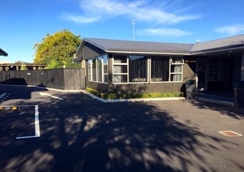 a house with a driveway in front of it at Aarburg Airport Motel in Christchurch