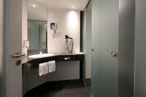 a bathroom with a sink and a mirror at Privathotel alte mühle Wolfsburg-Weyhausen in Wolfsburg