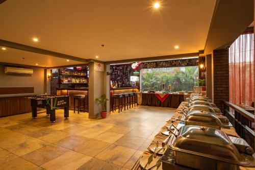 a bar with a row of tables in a room at Varanda Do Mar in Panaji