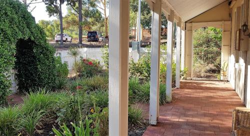 a porch of a house with a white fence at Tillbrook Cottage in Perth