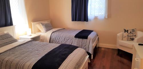 2 camas en una habitación pequeña con ventana en Tillbrook Cottage en Perth