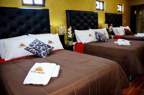a hotel room with two beds with certificates on them at Hotel Milenio Nanacamilpa Tlaxcala in Nanacamilpa