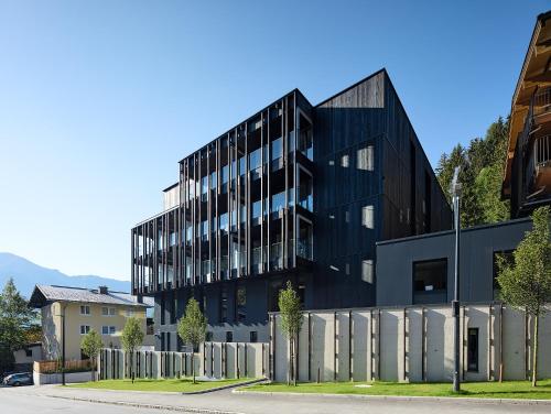 an office building with a black facade at Hotel Der Waldhof in Zell am See
