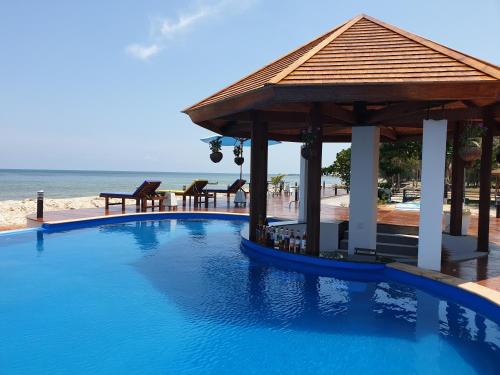 a swimming pool with a gazebo next to the beach at The Beach Resort & Residence - SHA Plus in Pathiu