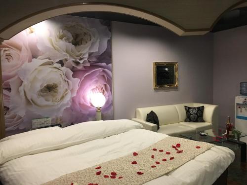 - une chambre avec un lit orné de roses peintes sur le mur dans l'établissement Hotel Water Gate Ichinomiya (Adult Only), à Inazawa
