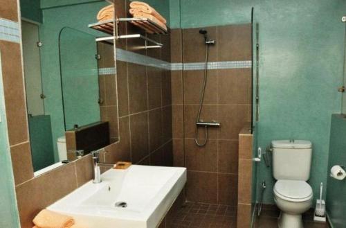 a bathroom with a sink and a toilet and a mirror at Casa Mara Dakar in Dakar