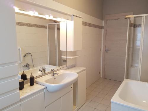 a white bathroom with a sink and a mirror at Alloggio Primosole in Fossano