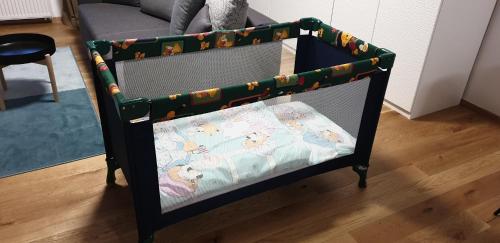 a crib in a room with a toddler bed with a blanket at The Gusto apartmán in Chomutov