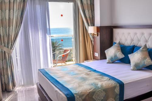 a bedroom with a bed with a view of the ocean at Cleopatra Golden Beach Hotel in Alanya
