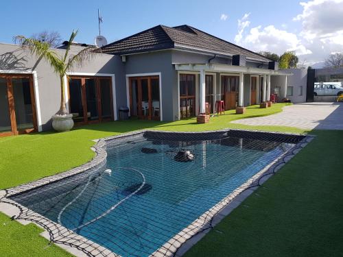 a swimming pool in the yard of a house at Two Fat Owls Guesthouse in George