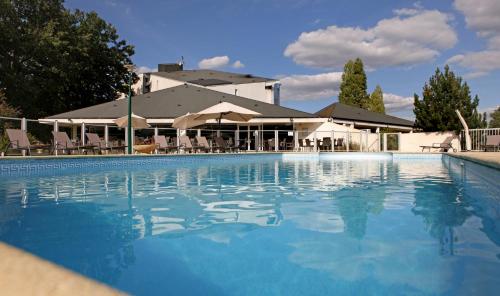 a large swimming pool in front of a hotel at Best Western Le Bois de la Marche in Poitiers