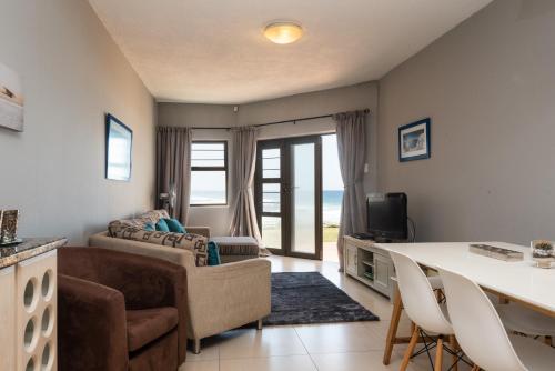 a living room with a couch and a table and chairs at The Bay 4 in Ballito