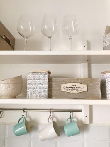 - une étagère avec des verres à vin et une boîte dans l'établissement Seaflat in Nice, à Nice