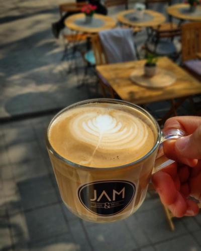 a person holding up a cup of coffee at JAM Luxury Apartment in Győr