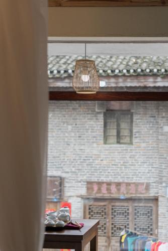 a window view of a brick building with a light fixture at Autumn Inn in Yangshuo