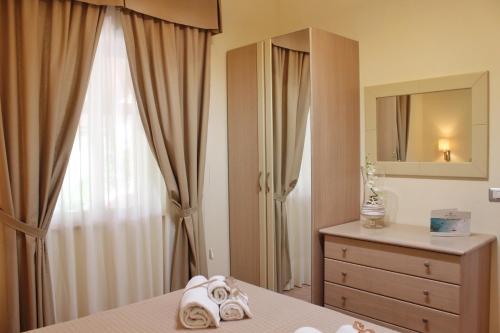 a bedroom with a bed and a dresser and a mirror at Blu Tropical Resort in Zambrone