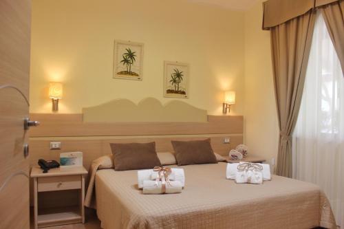 ein Schlafzimmer mit einem Bett mit zwei Handtüchern darauf in der Unterkunft Blu Tropical Resort in Zambrone