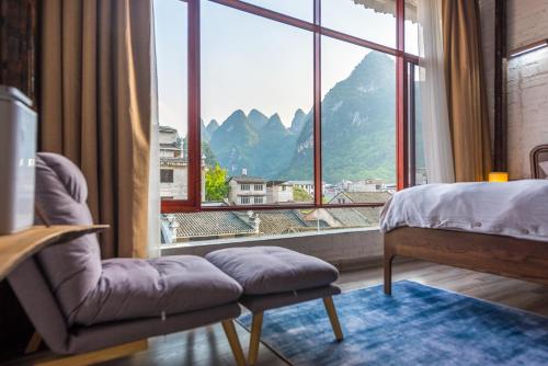 a bedroom with a bed and a large window at Autumn Inn in Yangshuo