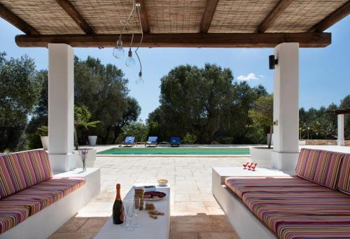 a patio with two couches and a table and a pool at Trullo Fico in Ostuni