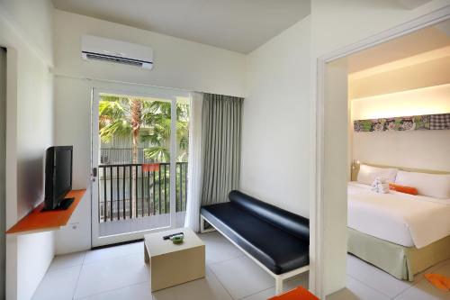 a hotel room with a bed and a balcony at HARRIS Hotel & Residences Sunset Road in Kuta