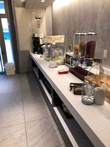 a kitchen with a counter top with food at Noku Osaka in Osaka