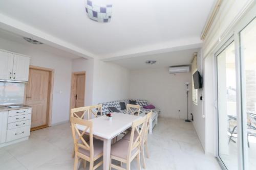 a kitchen and dining room with a table and chairs at Apartmani Tripović in Tivat