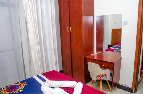a bedroom with two beds and a desk and a mirror at Sheratton Regency Hotel in Mombasa