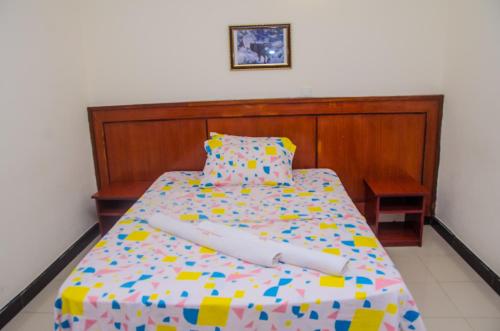 a bedroom with a bed with a wooden headboard at Sheratton Regency Hotel in Mombasa