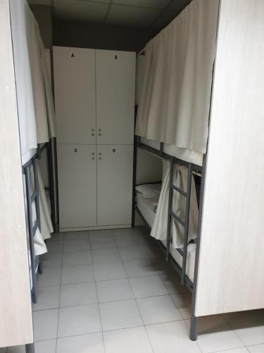 a room with two bunk beds and white cabinets at Albergue Porta Real NO BIKE STORAGE in Santiago de Compostela