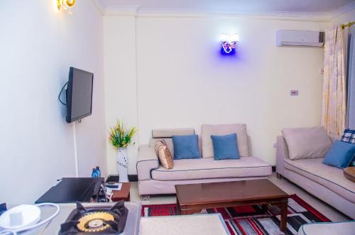 a living room with two couches and a tv at Sheratton Regency Hotel in Mombasa