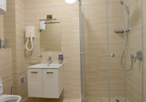 a bathroom with a shower with a sink and a toilet at Marseille Resort in Zatoka