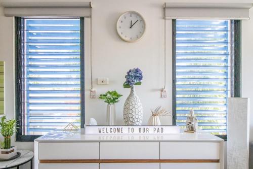 a room with two windows and a clock on the wall at ZEN QUEST - The NOMADS PAD Near Nightcliff Markets & Sunset Foreshore in Nightcliff