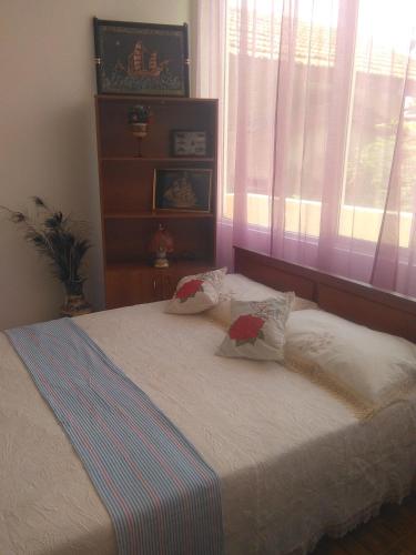 a bedroom with a bed with two pillows and a window at VILLA ARIANNA in Wattala