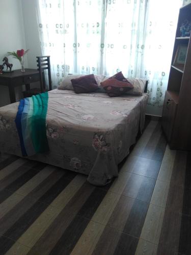 a bedroom with a bed with curtains and a wooden floor at VILLA ARIANNA in Wattala