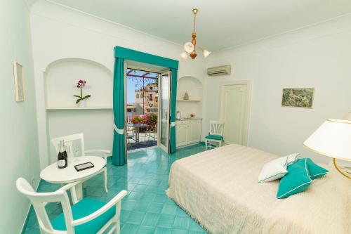 Schlafzimmer mit einem Bett, einem Schreibtisch und einem Tisch in der Unterkunft Casa Maresca Residence in Positano