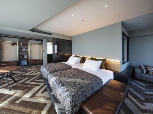 a hotel room with a large bed and a table at SHIBUYA STREAM HOTEL formerly Shibuya Stream Excel Hotel Tokyu in Tokyo