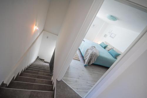 a bedroom with a blue bed and a staircase at Villa Mamma Mia Oprtalj in Oprtalj
