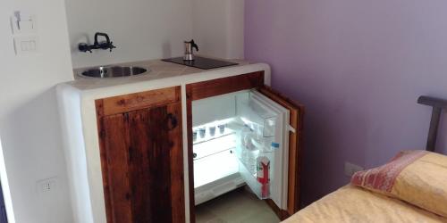 a small kitchen with a sink and a refrigerator at Corte Piri in Tricase