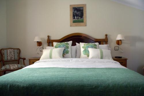 1 dormitorio con 1 cama grande con manta verde en Casa Rural Priena en Covadonga