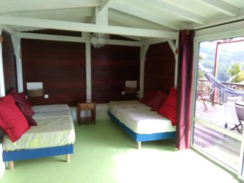 a bedroom with two beds and a balcony at cazabaltus in Bouillante