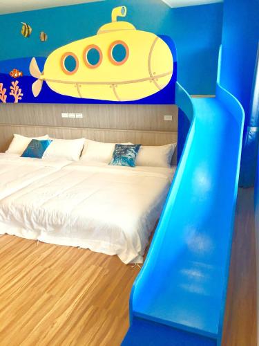 a bedroom with a bed with a submarine on the wall at Two Home Inn in Hualien City