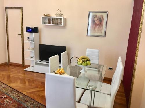 comedor con mesa de cristal y sillas blancas en Re Monza appartamenti in villa comodi per Milano en Monza