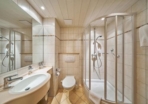 a bathroom with a shower and a sink and a toilet at Hotel Morjan in Koblenz