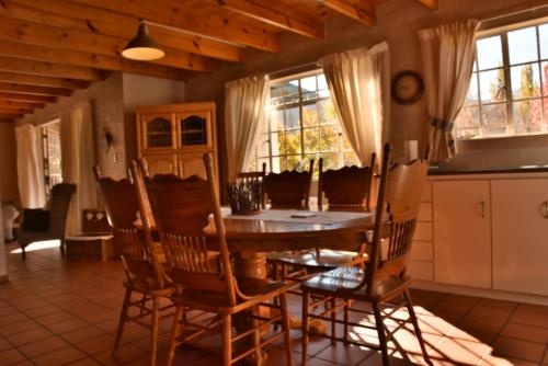 a dining room with a wooden table and chairs at Hillside Cottage in Clarens