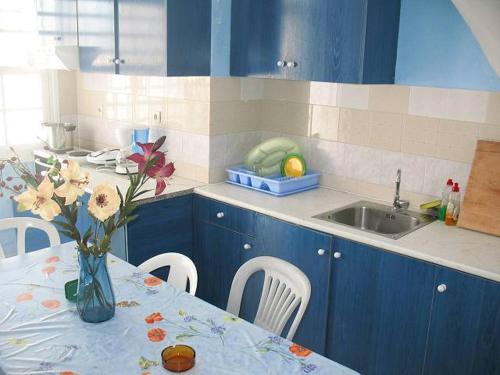 a kitchen with a table with a vase of flowers on it at Vesuvio Chora in Ios Chora